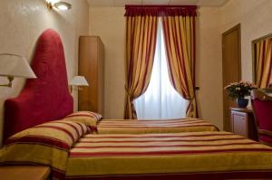ジェノヴァにあるホテル ブリニョールのベッドと窓が備わるホテルルーム