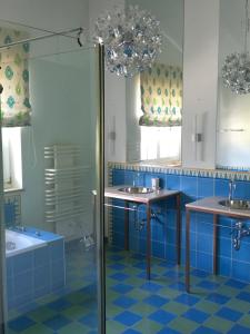 Ferienwohnung Hochkönig im Barbarahof في بيشوفشوفن: حمام أزرق مع مغسلتين ودش