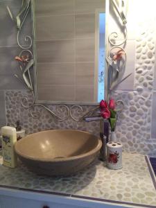 W łazience znajduje się umywalka i lustro. w obiekcie La Vigne Des Heures Claires w mieście Saint-Nazaire-dʼAude