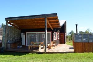eine kleine Hütte mit einer Terrasse und einem Tisch in der Unterkunft El Descanso del Quijote in Riñinahue
