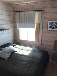 a bedroom with a bed with a window in it at Rukan Sarastus in Ruka