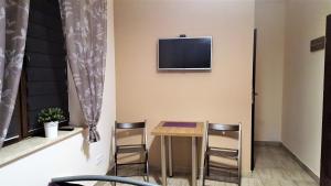 a room with a table and chairs and a tv on the wall at DobraNocka in Kaleń