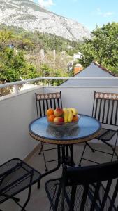 a bowl of fruit on a table on a balcony at Guest house Milic in Makarska