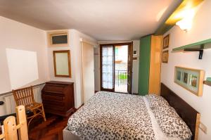a bedroom with a bed and a chair and a window at Il Tiglio in Moneglia