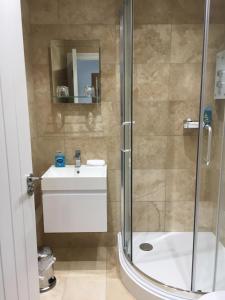 uma casa de banho com um chuveiro, um lavatório e um WC. em The Pityme Inn em Wadebridge