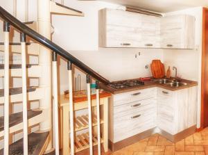 a kitchen with white cabinets and a staircase at Il Tiglio in Moneglia +2 photos