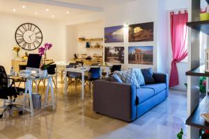 ein Wohnzimmer mit einem blauen Sofa und einem Esszimmer in der Unterkunft B&B Porta di Ponte in Agrigento