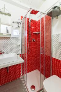 a red tiled bathroom with a shower and a sink at Casa Turano in Castellammare del Golfo