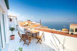 balcón con mesa, sillas y vistas al océano en Azzurro B&B, en Cefalú