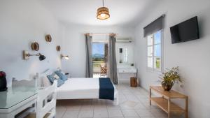 1 dormitorio con cama, escritorio y ventana en Ktima Bianco, en Naxos Chora