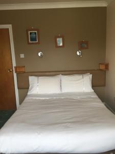 a bed with white sheets and pillows in a bedroom at Iveragh Heights in Cahersiveen