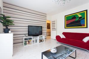 uma sala de estar com um sofá vermelho e uma televisão em Relax Apartment em Split