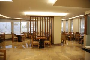 a restaurant with wooden tables and chairs and windows at Hotel Ponte Sor in Ponte de Sor