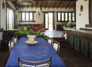 Habitación con mesa azul con sillas y sofá en Casa Panorâmica da Ferradura en Búzios