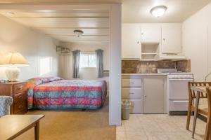 a small bedroom with a bed and a kitchen at Dayton Motel in Dayton