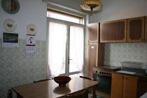 cocina con mesa de madera y ventana en B&B Il Glicine, en bedizzol