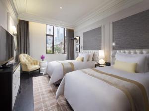 سرير أو أسرّة في غرفة في Golden Tulip New Asia Hotel The Bund Shanghai