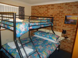 Cette chambre comprend deux lits superposés et un lit. dans l'établissement Dalmeny Shores Villas, à Dalmeny