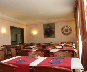 een eetkamer met tafels en stoelen met rode servetten bij Hotel La Palma in Lido di Camaiore