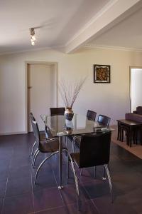 a dining room with a glass table and chairs at La Casa in Myrtleford