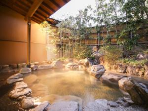 uma piscina de água com pedras num quintal em Ryokan Hirayama em Ueki