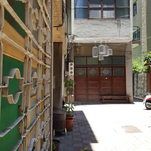 a building with a wooden garage door and a street at San Bu strolling in Tainan