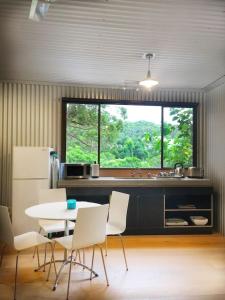 cocina con mesa, sillas y ventana en Avoca Beach and Bush, en Avoca Beach