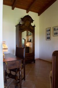 a room with a wooden table and a mirror at Domo Minnannu Miriu in Trudda +18 photos