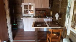 a kitchen with a table and a sink in a room at Domeczek Sami in Łunowo