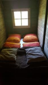 uma fila de almofadas numa cama num quarto em Domeczek Sami em Łunowo