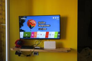 Un televisor de pantalla plana colgado en una pared amarilla. en Apartment Veseli, en Split