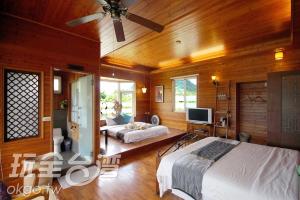 a bedroom with two beds and a flat screen tv at Moon River Villa in Puli