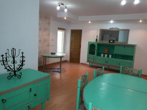 a dining room with a green table and a mirror at Casa Anca Hațeg in Haţeg