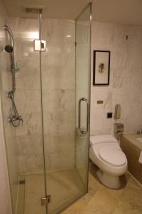 a bathroom with a toilet and a glass shower at Rongjiang Hotel in Jieyang