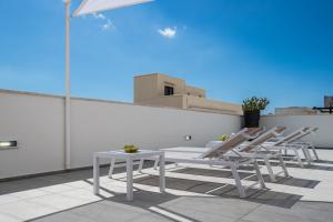 a group of chairs and a table on a roof at Palazzo Perla - Rooms and Suite in Gallipoli