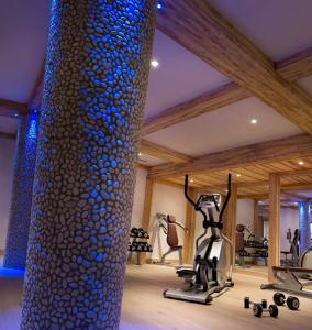 a gym with a large stone column and exercise equipment at CGH Résidences & Spas Les Chalets de Flambeau in Lanslebourg-Mont-Cenis