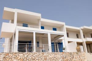 a white house with a stone wall in front of it at La Dimora Salento in Carovigno