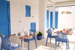 a dining room with blue chairs and a table at La Dimora Salento in Carovigno