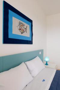a bedroom with a bed with a picture on the wall at La Dimora Salento in Carovigno