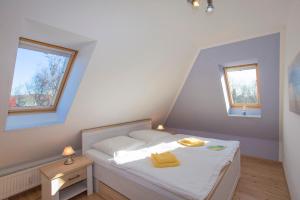 ein kleines Schlafzimmer mit einem Bett und zwei Fenstern in der Unterkunft Ferienwohnung Wiek - Haus Meeresblick in Wiek auf Rügen 