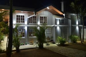 a white house with palm trees in front of it at night at Tea Hills Bungalow in Hatton