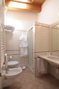 a bathroom with two sinks and a toilet and a shower at Hotel Acropolis in Cattolica
