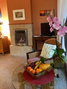 a bowl of fruit on a table in a living room with a fireplace at At the Craters Edge in Volcano
