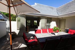 a patio with a table and chairs and an umbrella at Tranquil Tokai in Tokai