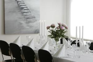 a white table with a vase of flowers on it at Brattvåg Fjordhotell in Brattvåg