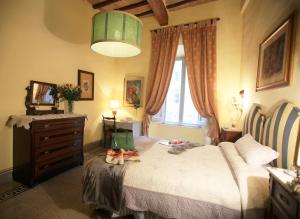 um quarto com uma cama com uma cómoda e uma janela em B&B Le Aquile em Siena