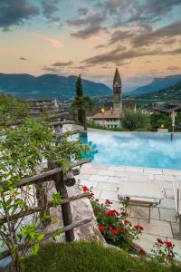 a resort with a pool and a church at Hotel Kassian in Lagundo