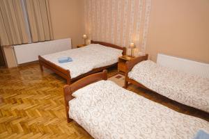 a room with three beds and a table at Amfora in Palić