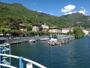 a river with boats docked at a dock in a town at Hotel Belvedere in Lovere