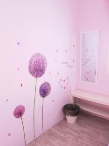 une chambre avec des fleurs violettes sur le mur dans l'établissement MILU Homestay - Kuala Selangor, à Kuala Selangor